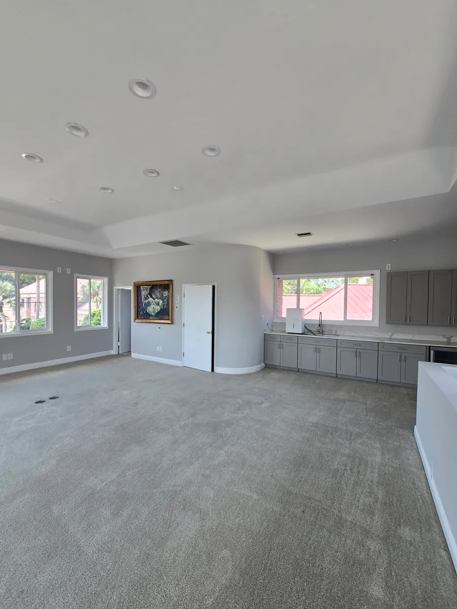 Open interior room with gray walls, a white ceiling and trim, and gray cabinetry